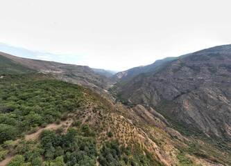 Fototapeta na wymiar panoramic views of ancient temples and buildings in picturesque places in a gorge in the mountains of Armenia taken from a drone