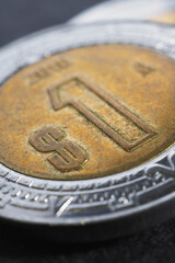 Coin of 1 one Mexican peso close-up. Peso of Mexico. News about economy or currency. Loan and credit. Money and taxes. Focus on peso sign. Vertical illustration. Macro