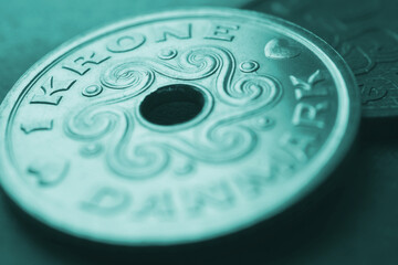 1 Danish krone coin closeup. National currency and money of Denmark. Turquoise tinted background for news about economy or finance. Loan and credit. Tax and inflation. Macro