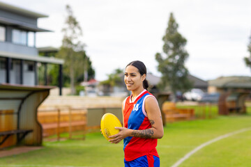 one female football player holding yellow football