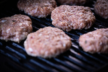 Raw ground meat traditional Bulgarian grilled meat balls called kyufte just placed on the BBQ