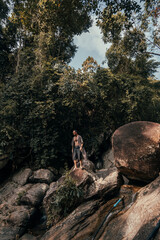 Obraz premium handsome bearded man posing on a mountain in the jungle, tourist traveler