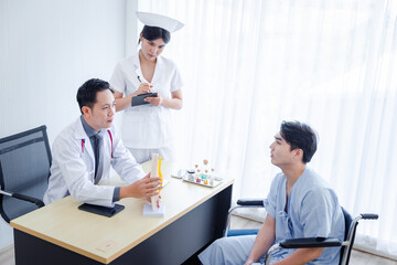 Asian male orthopedic professional doctor and nurse consulting explaining knee bone model to male patient