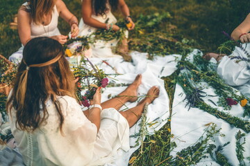 View of women making wreaths with beautiful flowers.