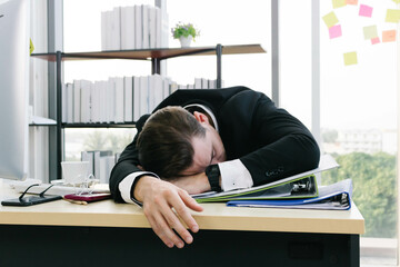 Frustrated caucasian businessman take a nap at his desk.