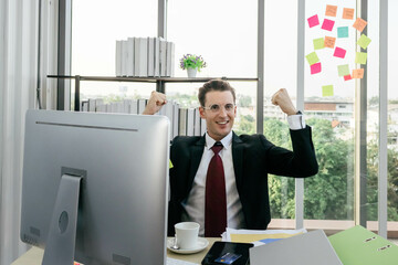 A young caucasian businessman is feeling happy and excited about his achievement. Succesful work concept.