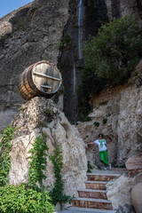 waterfall against the backdrop of a beautiful rock and decorated with a wine barrel and clay jugs...