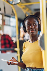 African american woman riding a bus and using a smartphone