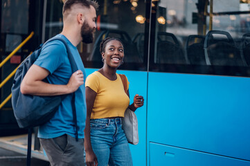 Multiracial friends waiting for a public transport at a bus stop