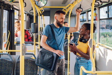 Multiracial friends talking and using a smartphone while riding a bus in the city © Zamrznuti tonovi