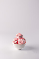 Meringue crispy. Air dessert in pink color on a white background. Marshmallow raspberry.