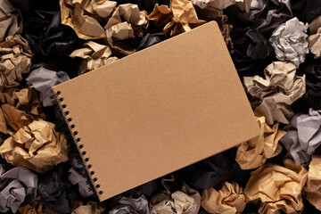 Notebook on crumpled paper balls as background texture. Inspiration idea concept
