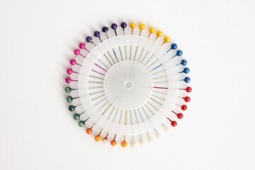 rainbow colored sewing needles in round circle packaging
