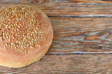 Homemade bread with sunflower seeds on dark wooden table