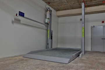 Empty Space in Automatic Elevator double stack car park. Hydraulic lift. Empty garage. Hydraulic...