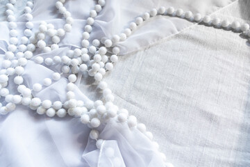 pearl necklace on white silk, background for wedding concept