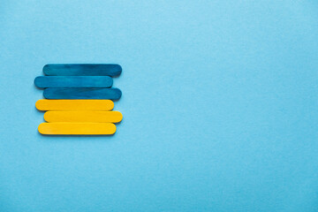 Ukraine flag on a blue background from the side, free space. Place for text. Stick flag.