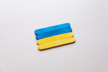 flag of ukraine from wooden sticks on a gray background