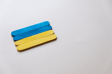 flag of ukraine from wooden sticks on a gray background, free space