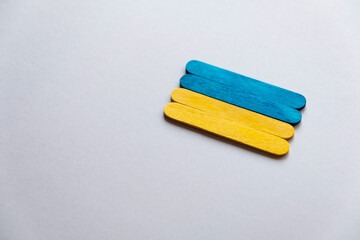 flag of ukraine from wooden sticks on a beige background. Ukrainian flag.