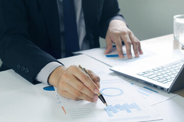 Business man analyzing chart and graph showing changes on the market.On the table in the office, the concept of calculating investment results.