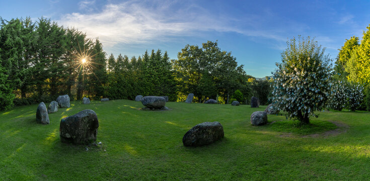panorama landscape of the Kenmare Standing Stones and Wishing Tree in warm evening light with a sunburst