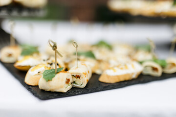 nature catering. Bruschetta on a black plate on the table. Party concept and delicious appetizers with fresh vegetables and meat. 