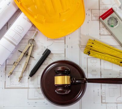 Construction and Labor law flat lay. Judge gavel and design tools on building blueprint