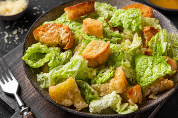 Classic Caesar salad with crisp homemade croutons, parmesan cheese and caesar dressing in a plate