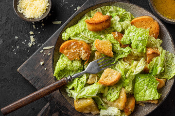 Caesar salad with crisp crotons, parmesan cheese and dressing for tasty lunch or dinner in a plate with fork © samael334