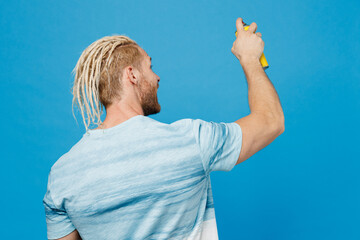 Back view young cool fun happy blond man with dreadlocks 20s he wearing white t-shirt hold in hand...