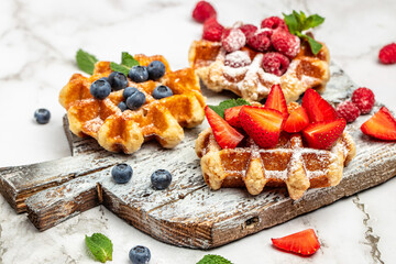 Berry Belgian Waffle with raspberries, strawberries and blueberries. Culinary, cooking, bakery concept. Food recipe background. Close up