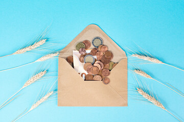 Envelope with wheat and Euro banknotes, food shortage and increasing prices, poverty through...