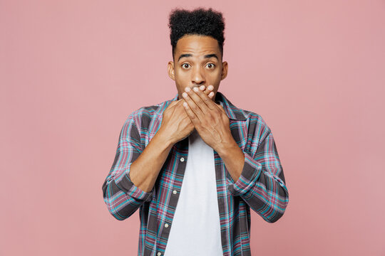 Young Surprised Scared Sad Shocked Man Of African American Ethnicity 20s Wear Blue Shirt Cover Mouth With Hand Isolated On Plain Pastel Light Pink Background Studio Portrait. People Lifestyle Concept.