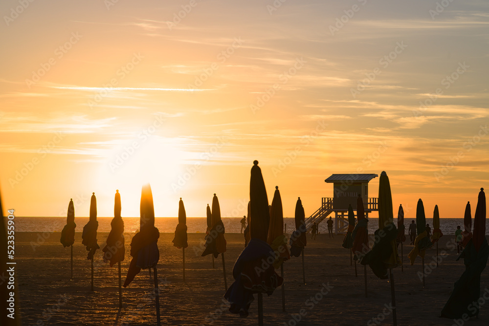 Wall mural sunset behind the parasols of deauville in normandy - Wall murals