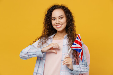 Young smiling happy black teen girl student she wear casual clothes backpack bag hold british flag...