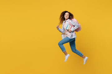 Fototapeta na wymiar Full body young black teen girl student she wear casual clothes backpack bag jump high look camera run fast hurrying isolated on plain yellow color background. High school university college concept.