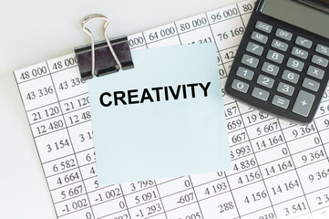 Creativity text on a card clip to a sheet of paper with numbers on a table, a business concept