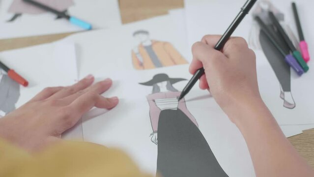 Close Up Of Female'S Hand Designing Clothes On The Paper In The Studio

