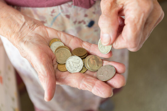 The hand of an elderly woman with coins, Rubles from pensioner