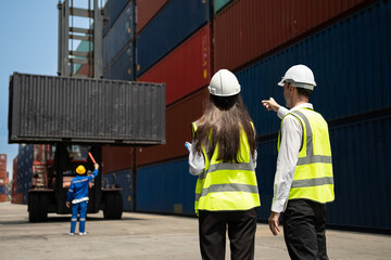 Caucasian two businessman and businesswoman working in container site.  Attractive engineer people...