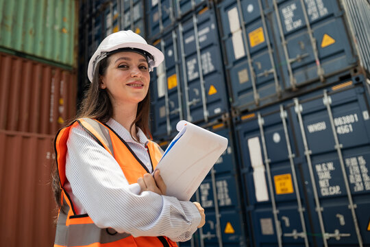 Portrait Caucasian woman worker working in container port terminal. Attractive female engineer people process orders and product at warehouse logistic in cargo freight ship for import export in harbor