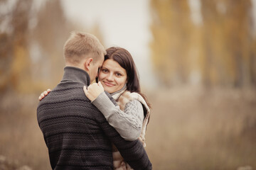 couple on autumn walk outdoors. Two lovers in autumn park. Love and tender touch. Foggy cloudy day filled with the warmth of love. Beautiful autumn landscape for couple