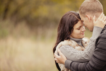 couple on autumn walk outdoors. Two lovers in autumn park. Love and tender touch. Foggy cloudy day filled with the warmth of love. Beautiful autumn landscape for couple