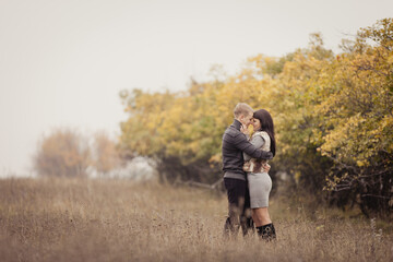 couple on autumn walk outdoors. Two lovers in autumn park. Love and tender touch. Foggy cloudy day filled with the warmth of love. Beautiful autumn landscape for couple