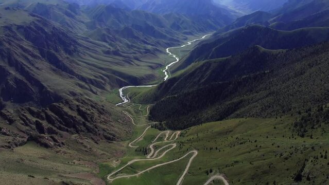 Teskey Torpock Pass (33 parrots) near to city Naryn and Son Kel lake in Kyrgyzstan. Epic slow movement from drone. Car ride on mountain road. 