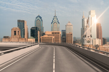 Empty urban asphalt road exterior with city buildings background. New modern highway concrete construction. Concept way to success. Transportation logistic industry fast delivery. Philadelphia. USA.