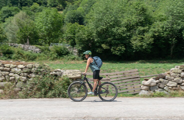 Fototapeta premium woman riding an electric bicycle in the countryside