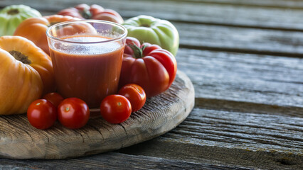 Close up of tomato juice surrounded by tomatoes and copy space to the right.