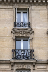 Fototapeta na wymiar Traditional old French house: balconies and windows. Paris, France.